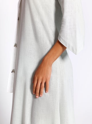Detail view of asymmetrical offset panel on linen kaftan
