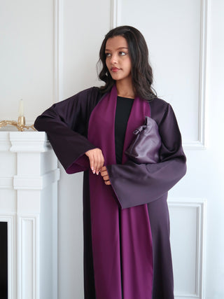 Close up of inside out abaya showing rich plum satin lining and fluid drape with relaxed modern silhouette