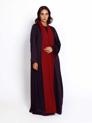 Woman wearing a black and red abaya on a white background