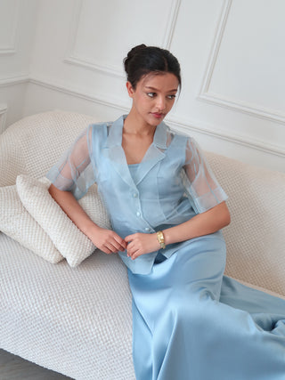 Close up of organza layered dress with sheer overlay top and soft blue satin base, showing delicate texture and structure